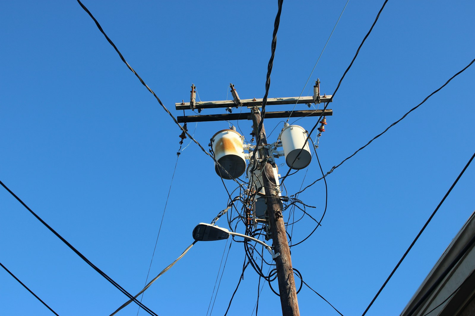 Nättransformatorer och ett nät av luftledningar mot en klar himmel.